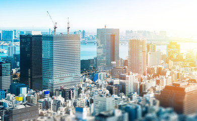 Business and culture concept - panoramic modern city skyline bird eye aerial view under dramatic blue sky in Tokyo, Japan. miniature lens tilt shift blur effect