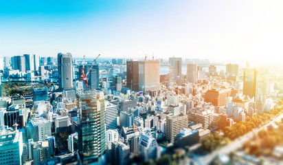 Business and culture concept - panoramic modern city skyline bird eye aerial view under dramatic blue sky in Tokyo, Japan. miniature lens tilt shift blur effect - obrazy, fototapety, plakaty