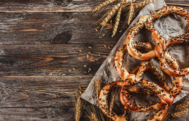 Bavarian pretzels with with sunflower seeds, brown wooden background. Copy space and top view