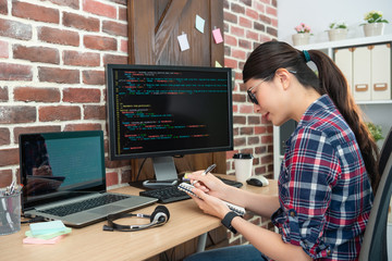 female programmer working and writting