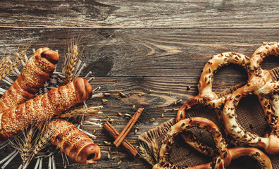Pretzels with sunflower seeds, sausages in dough and cinnamon sticks. Selective focus, top view