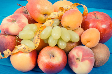 Tape measure with fresh natural fruits containing nutritious vitamins for healthy lifestyles