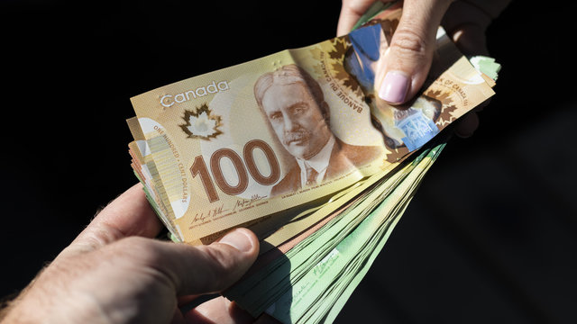 Hands Holding a Bunch of Canadian Cash