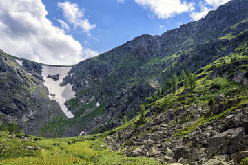 Naklejka na ściany i meble Summer Mountain Landscape: View of Ravine covered by Snow at Siberian Rocks