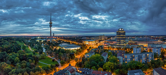 Fototapeta premium Die BMW Welt und der Münchner Olympiaturm am Abend beleuchtet