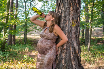 Pregnant woman drinking wine in the park - alcoholism concept