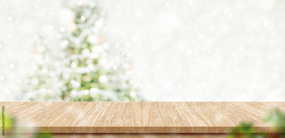 Aufkleber Empty brown wooden table top with abstract muted blur christmas tree and snow fall background with bokeh light,Holiday backdrop,Mock up banner for display or montage of product.