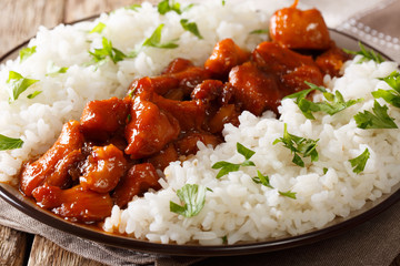 Bourbon chicken in spicy sauce with whiskey served with rice on a plate. horizontal