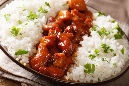 Bourbon chicken with garnish of rice close-up served on a plate. horizontal
