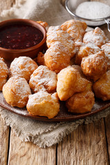 Albanian donut petulla with raspberry jam and powdered sugar close-up on a plate. vertical