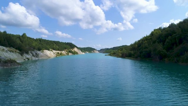 An abandoned plaster pit filled with blue water.