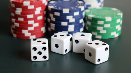 Casino chips and dice on the dark green background.