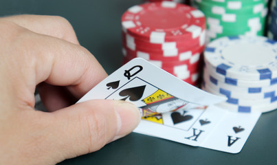 The woman's hand turning over the card with the casino chip.