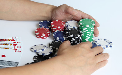 The both hands of a woman pulling a casino chip.