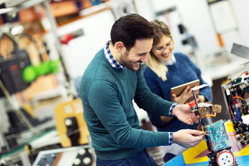 Young attractive students of mechatronics working on project