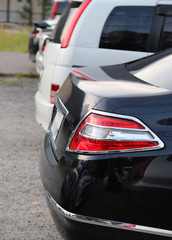 Obraz na płótnie Canvas Closeup of rear side of black car park in parking area. Vertical view.