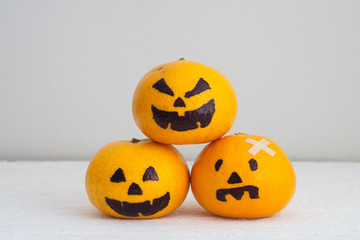 Fresh Orange with Head Pumpkins  haunted spooky face  easy DIY decoration for Halloween festival, on white wood with copy space