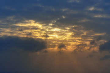 Sun rays breaking through the dark clouds at sunset
