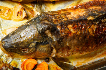 closeup roasted whole stuffed fish with vegetables