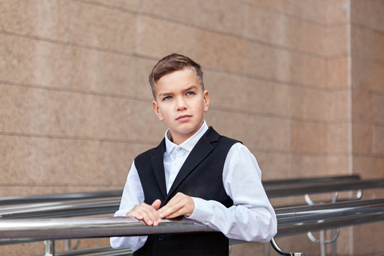 Portrait of schoolboy in uniform near school