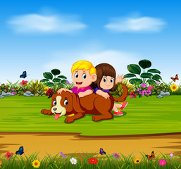 the boy and the girl are playing with their dog in the garden 
