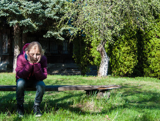 Sad girl sitting on a bench.