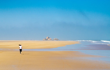 Fototapeta na wymiar Runner on beach of Essaouira