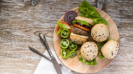 Food banner. Grilled homemade burgers with beef, tomatoes, cheese, sweet onions and green salad. Top view