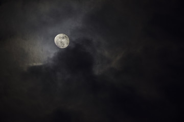 Naklejka na ściany i meble Full moon in the middle of clouds