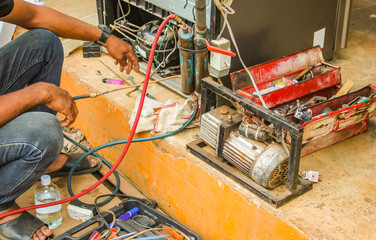 technician vacuum system refrigerator at maintenance shop.