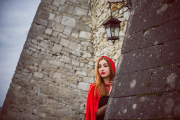  Concept of Halloween. Beautiful and simple costume of little red hood. Mysterious hooded lady figure . Girl in red raincoat. Cosplay Fairy Tale Little Red Riding Hood 