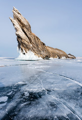 Winter landscape, cracked frozen lake with beautiful mountain island on frozen lake Baikal in Siberia, Russia