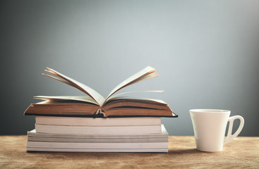 Coffee cup with books on wooden table. Education concept