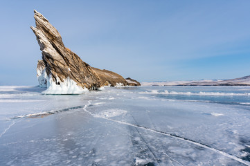 Winter landscape, cracked frozen lake with beautiful mountain island on frozen lake Baikal in Siberia, Russia