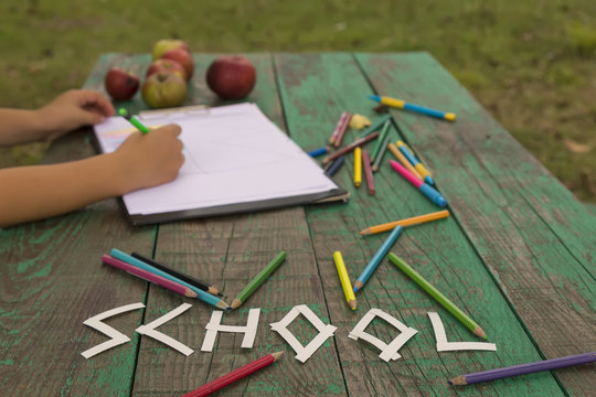 the child draw picture with colorful pens on the wooden green table in the nursery or school for lesson activity concept. creative ideas for child development.back to school.