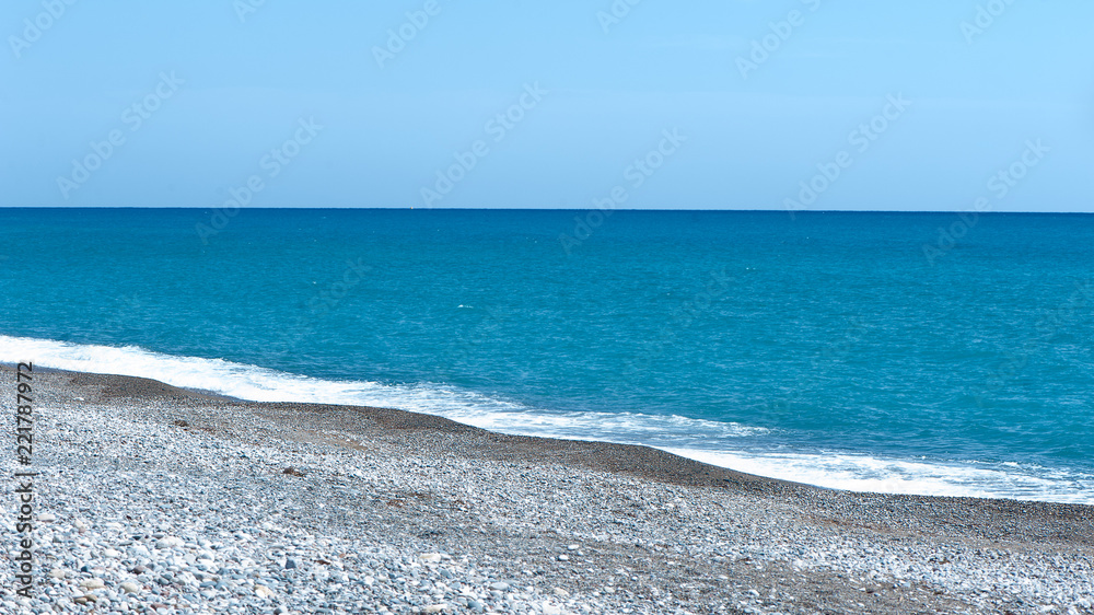 Wall mural beautiful blue sea and stony shore