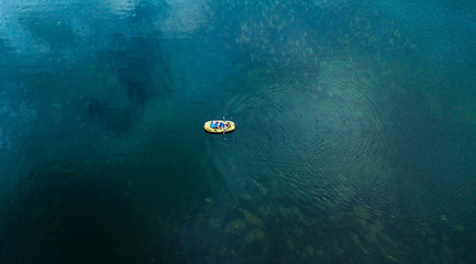 Direct above shot of yellow boat at the surface of the lake