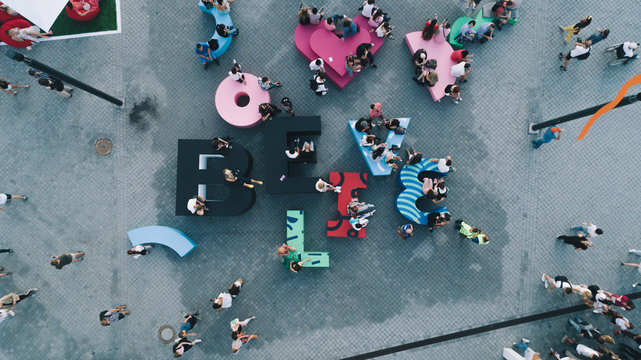 Aerial view of people. Young guys and girls are sitting on their letters.
