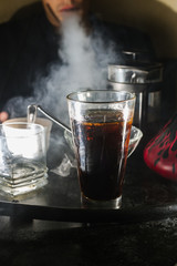 a glass of whiskey, or rum, or alcohol stands on a table on a dark background in the bar