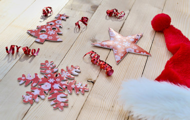 red christmas decoration, ribbon and santa hat on wooden baclground