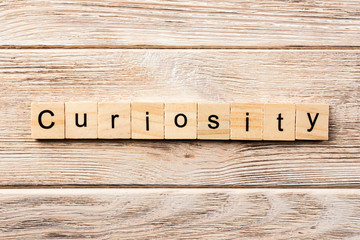curiosity word written on wood block. curiosity text on table, concept