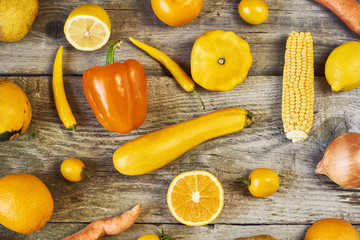 Assorted types of yellow fruits and vegetables on wooden background. Top view