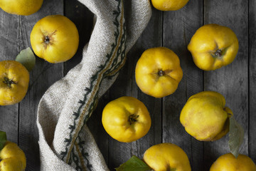 A lot of apple quince  on dark wooden background. top view