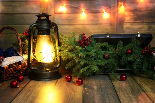 New Year composition of branches of Christmas trees decorated with balls Vintage lamp with burning candles