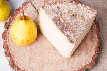 cheese with a pear on a wooden background