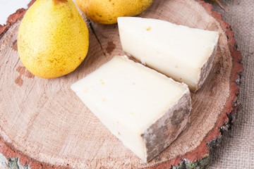cheese with a pear on a wooden background