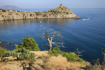 Beautiful scenic landscape of the Crimean coast, bay behind the cape, trees and the sea