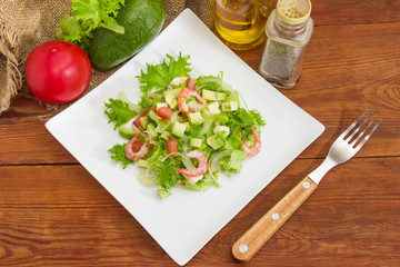 Avocado salad with vegetables, mozzarella, shrimps, closeup among some ingredient
