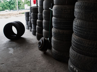 Used car tires stacked in piles at tire fitting service. Wheels for repair shop. Car service concepr