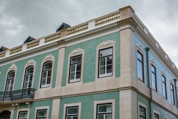 Fototapeta na wymiar Green tile building corner view against cloudy sky